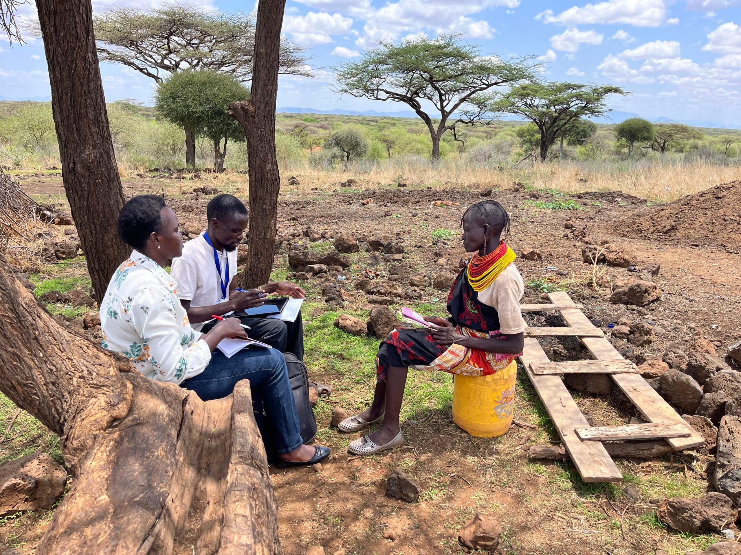 Two researchers sitting and talking to local community member