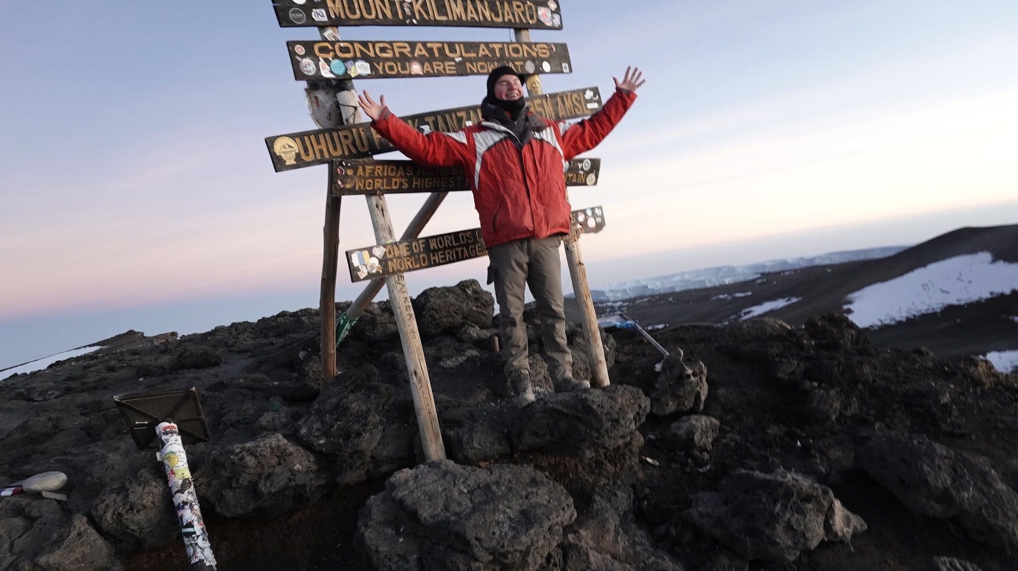 Luke Keller stands at the top of Mount Kilimanjaro