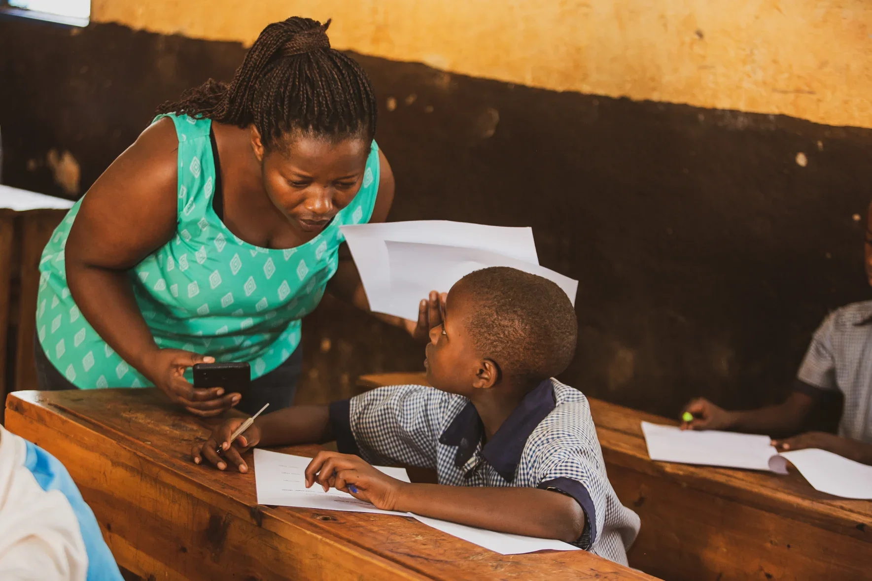 Rwandan teacher gives instruction to student